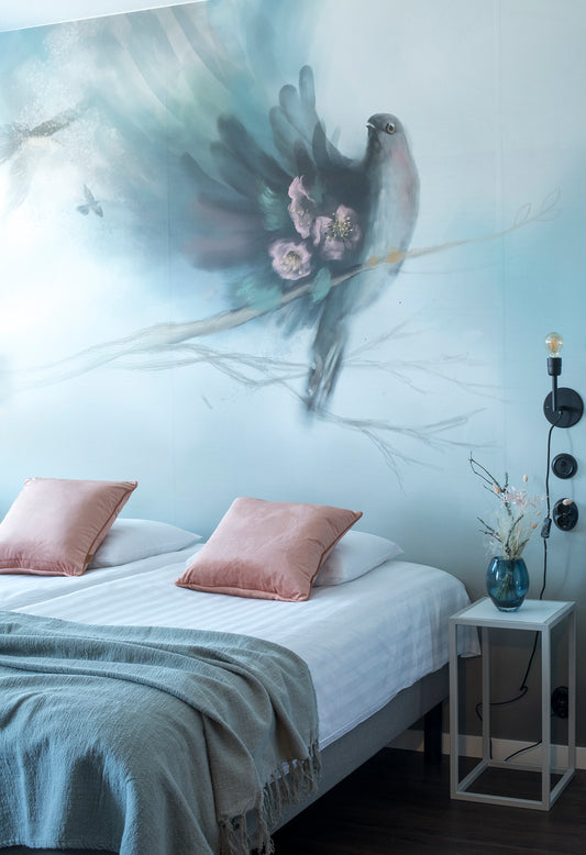 Kuvassa moderni muraalitapetti. Kaunis tapetti kodin sisustukseen. Aiheena lintu ja tarina. Tapetti sopii esimerkiksi sängyn taustaseinälle. Mattapintainen kuitutapettimateriaali. Lähellä ja kotimaisesti suunniteltu ja painettu. Pehmeä tunnelma kotiin tai julkiseen tilaan. Tapetti on ekologinen ja helppo asentaa. Poisto ei jätä liimajälkiä.